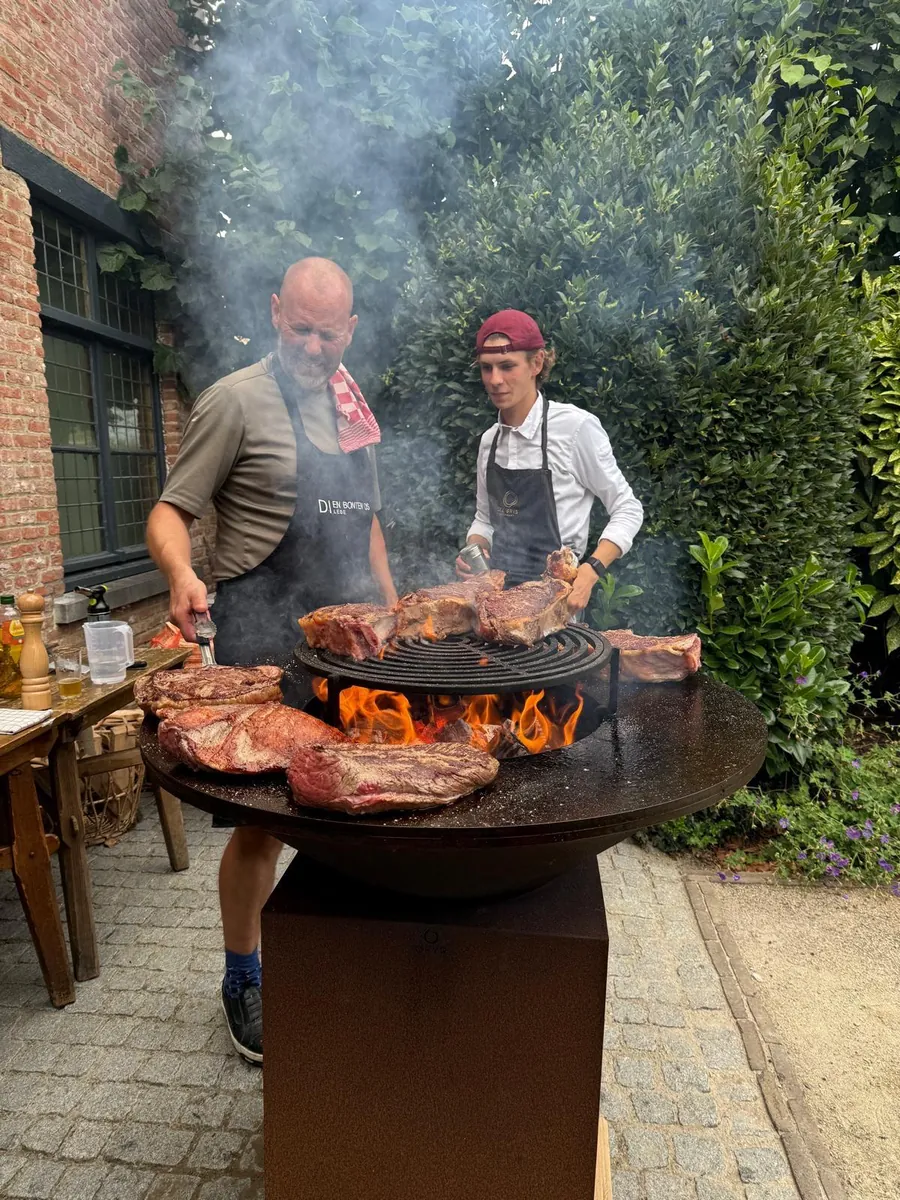 De chefs aan de barbecue in de tuin